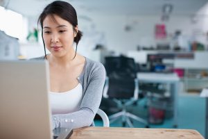 Smiling businesswoman working at laptop in office